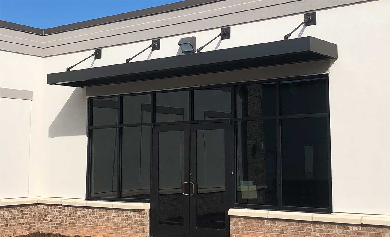 Black canopy designed to shade an entrance in the summer time.