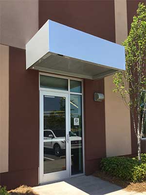 Single door with sidelights covered by a commercial canopy